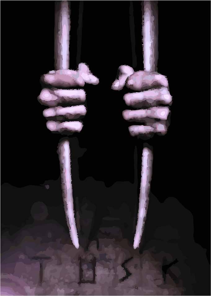 Tusk: Hands gripping bars in darkness