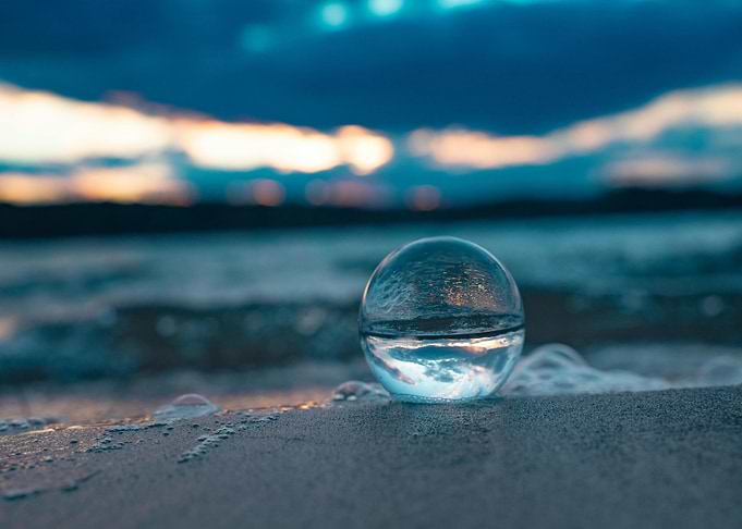 Crystal ball on beach at sunset