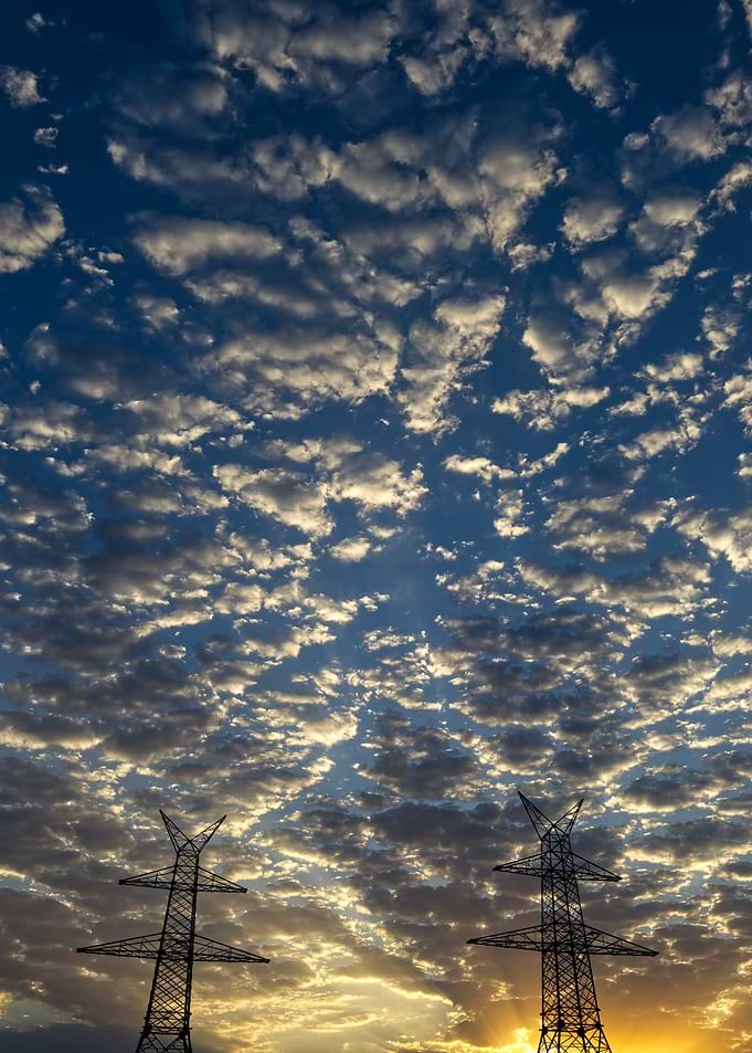Power Lines Under Cloudy Sky at Sunset