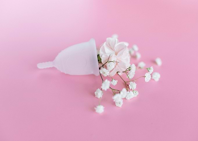 Menstrual cup with flowers on pink