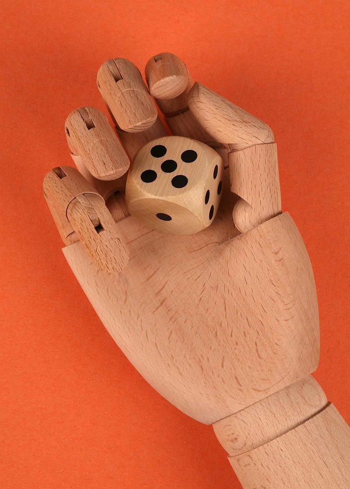 Wooden Hand Holding a Dice