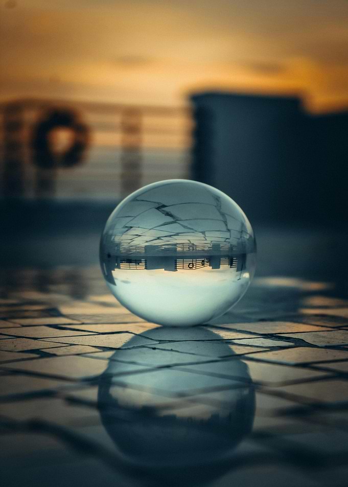 Crystal ball reflecting cityscape at sunset