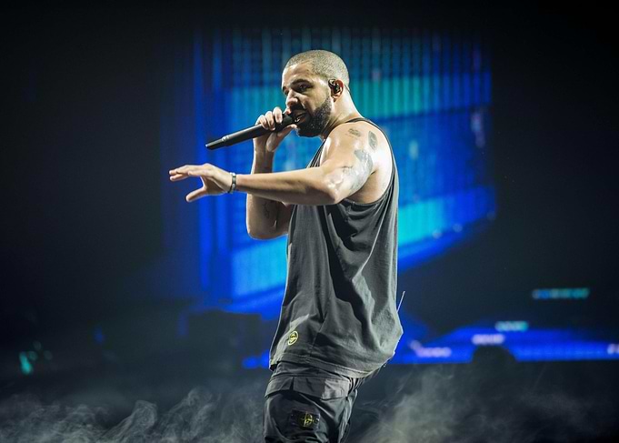 Drake performing on stage with microphone