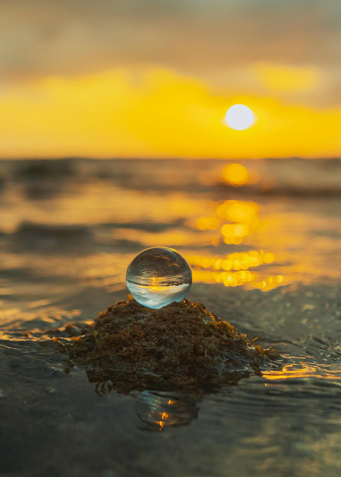 Crystal ball on rock at sunset