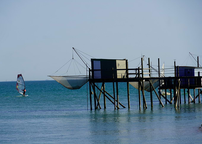 Windsurfer and Fishing Huts on Stilts