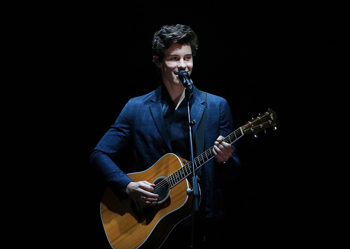 Shawn Mendes performing with guitar