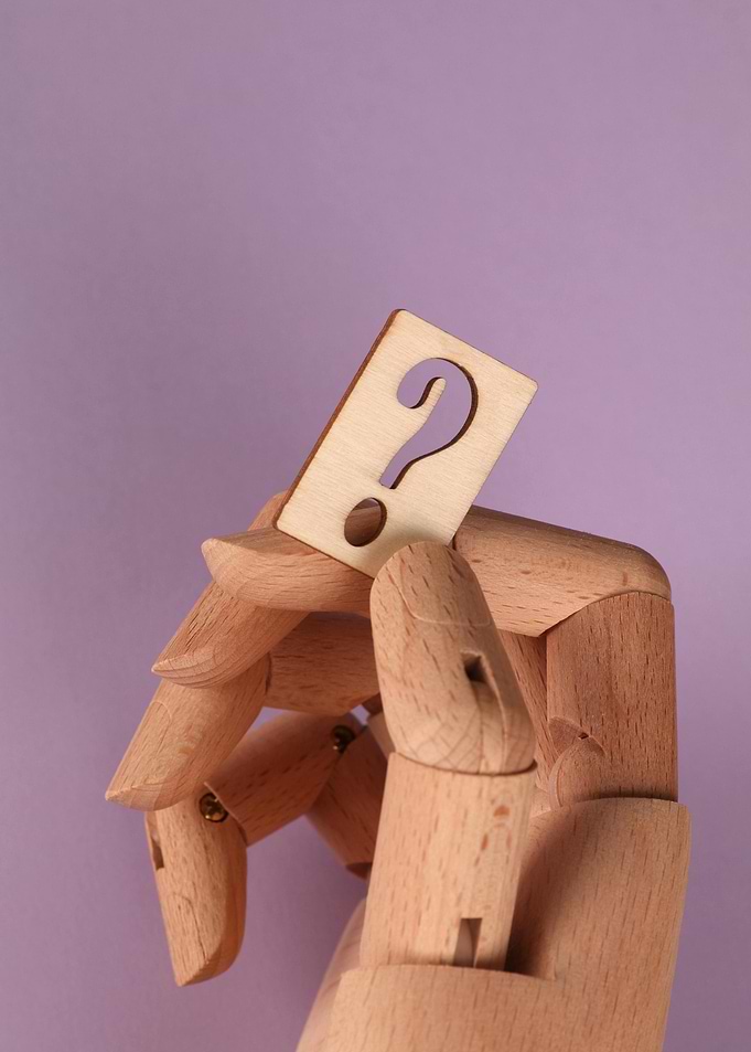 Wooden Hand Holding Question Mark