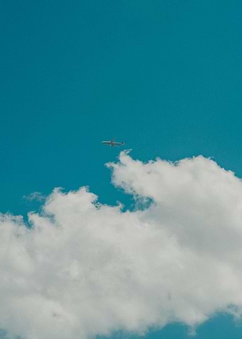 Airplane in Blue Sky with Clouds