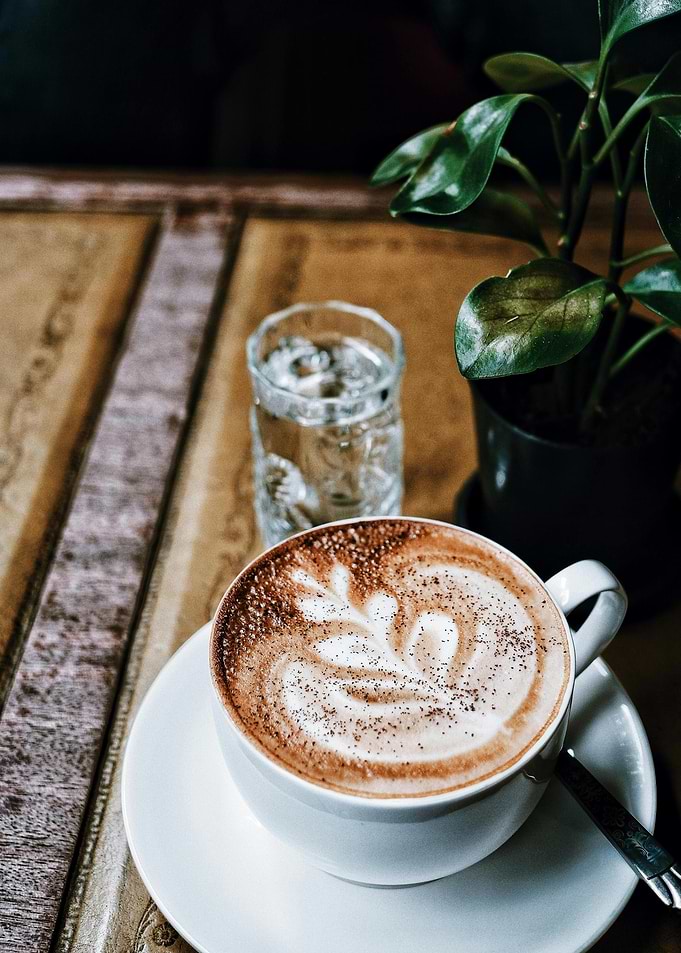 Cappuccino with latte art on wooden table