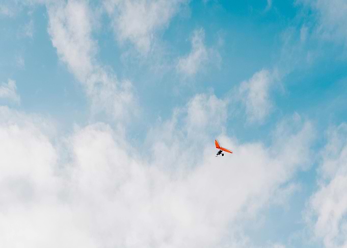 Hang glider soars in cloudy sky