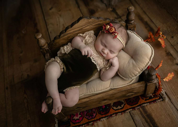 Sleeping Newborn in Wooden Bed