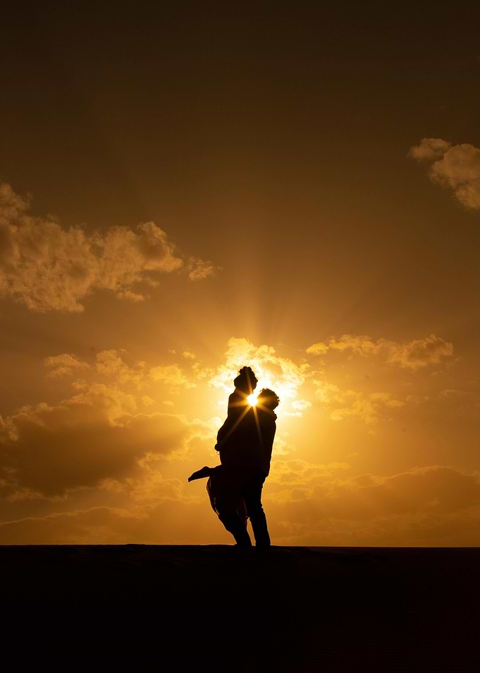Silhouette of Couple Embracing at Sunset