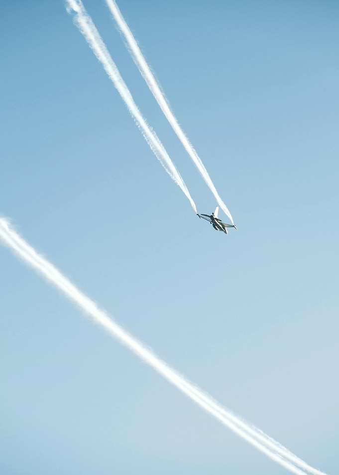 Jet plane with contrails in blue sky