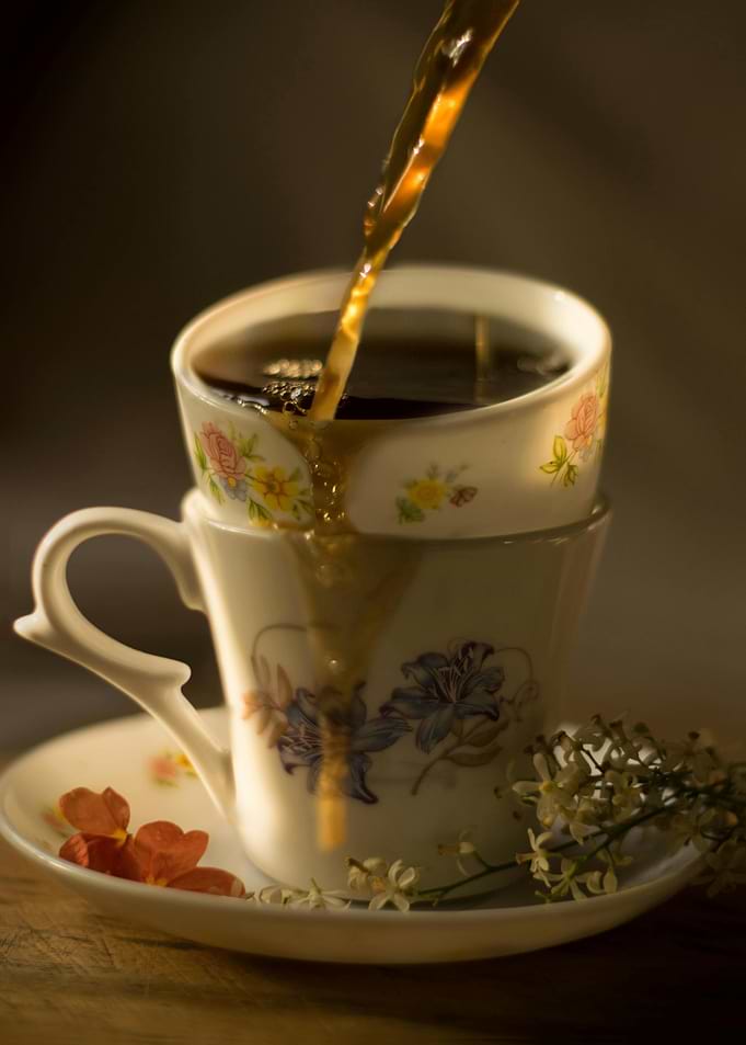 Pouring coffee into floral teacups