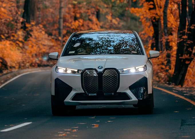 White BMW iX on Autumn Road