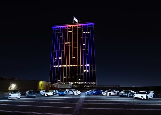 Luxury Cars at Night with Skyscraper