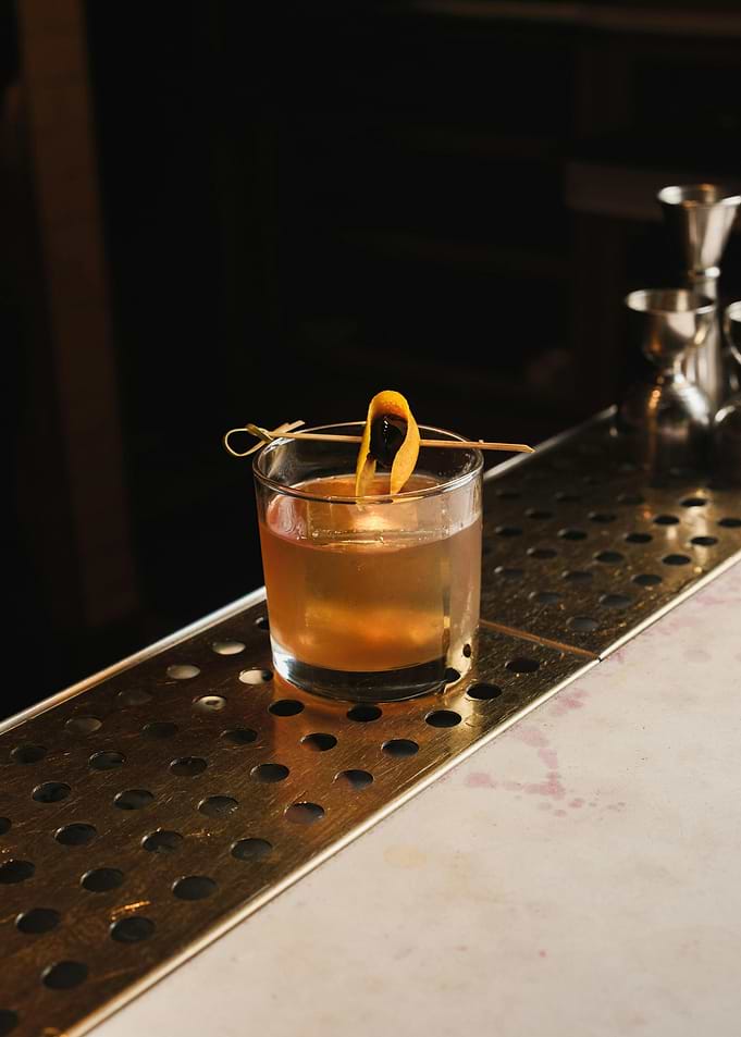 Cocktail with Orange Peel on Bar