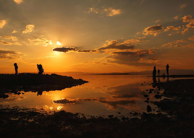 Sunset Reflection with Silhouetted Figures