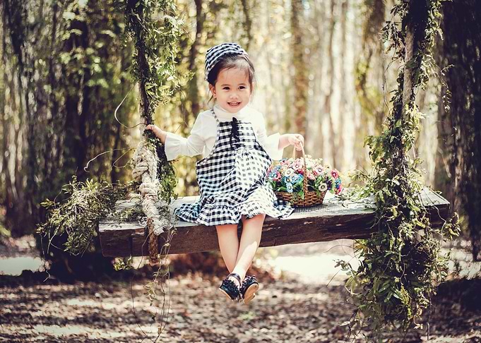 Girl on a swing with flowers