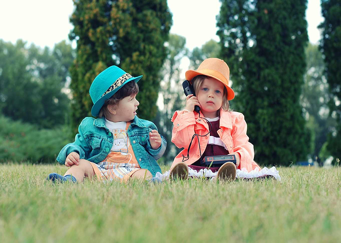Two children playing with old phone