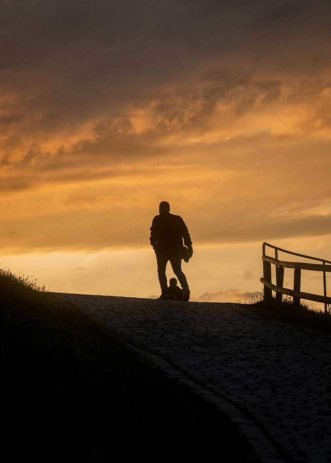 Silhouette of man and child at sunset