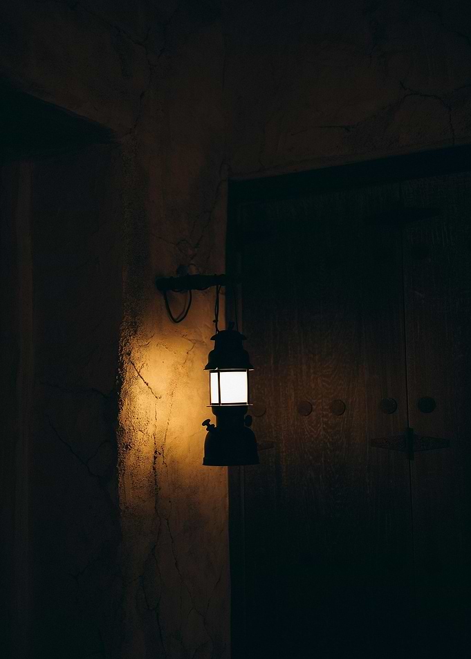 Illuminated Lantern Against Dark Wall