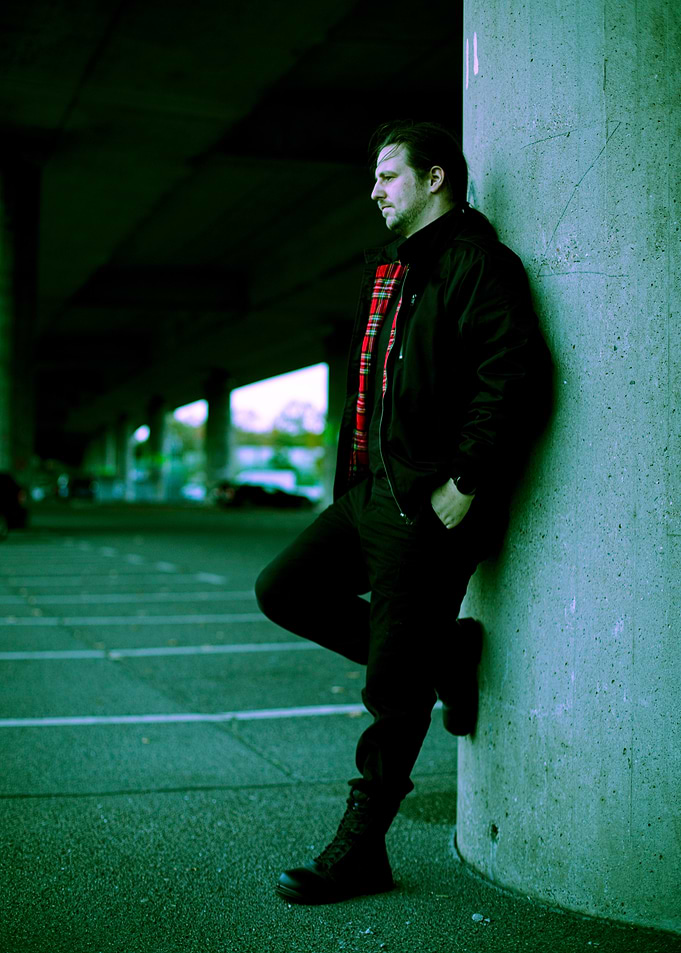 Man Leaning Against Concrete Pillar