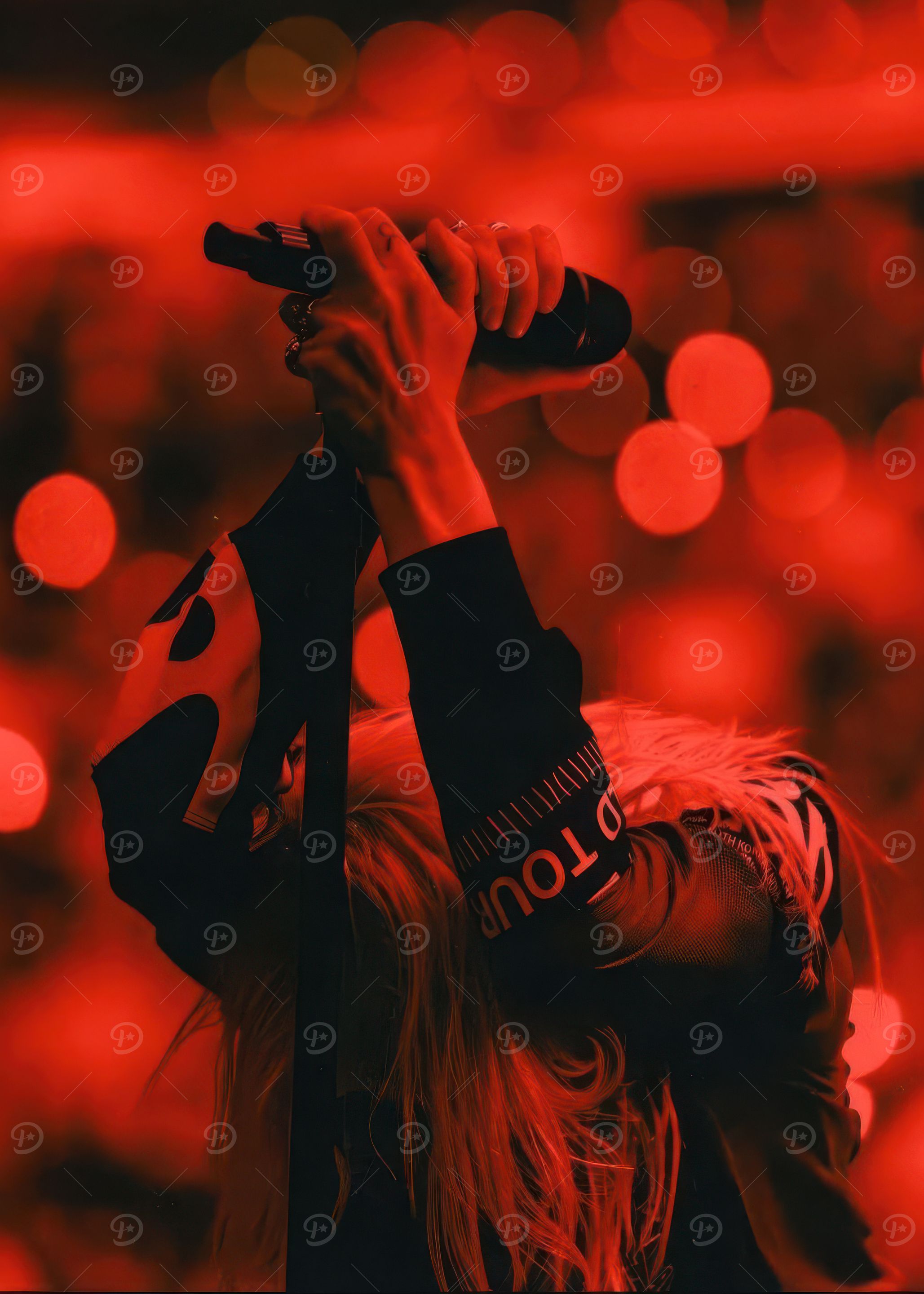 Singer performing on stage in red light
