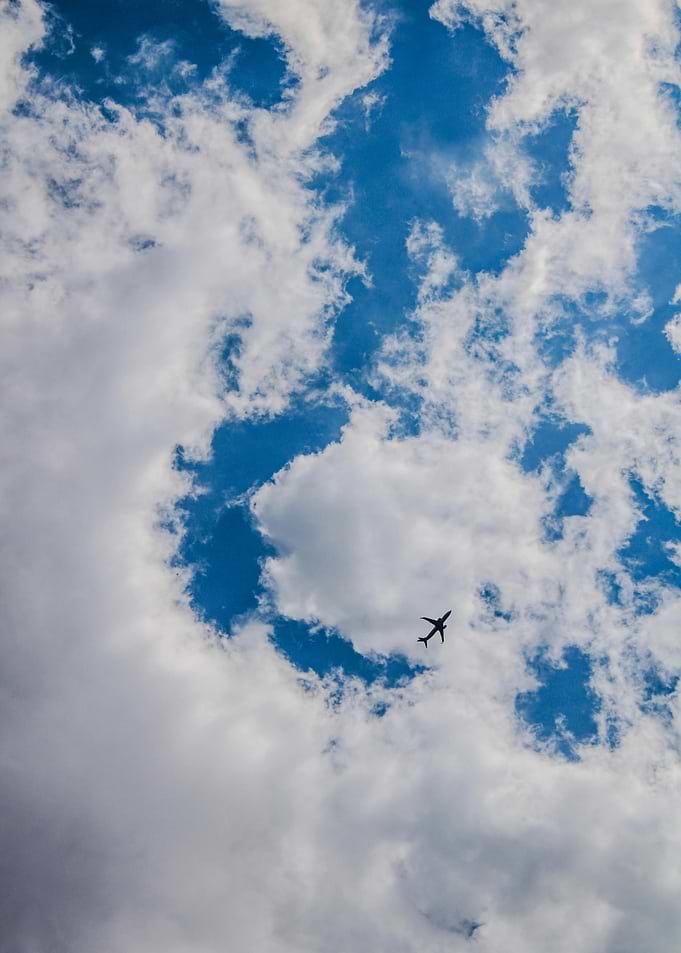 Airplane in Blue Sky with Clouds