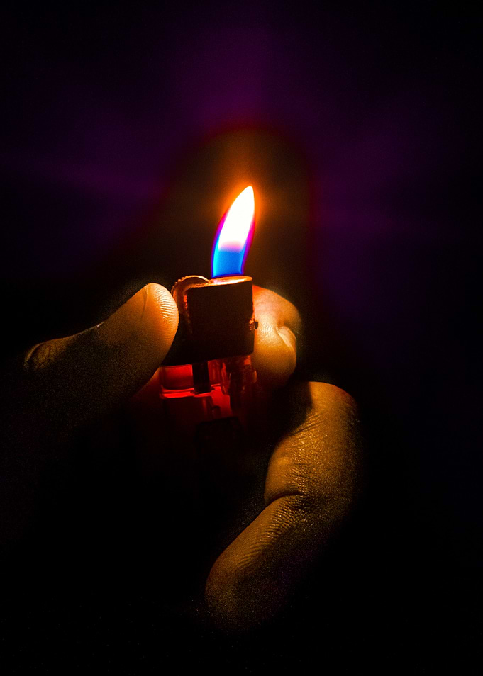 Hand holding a lit lighter
