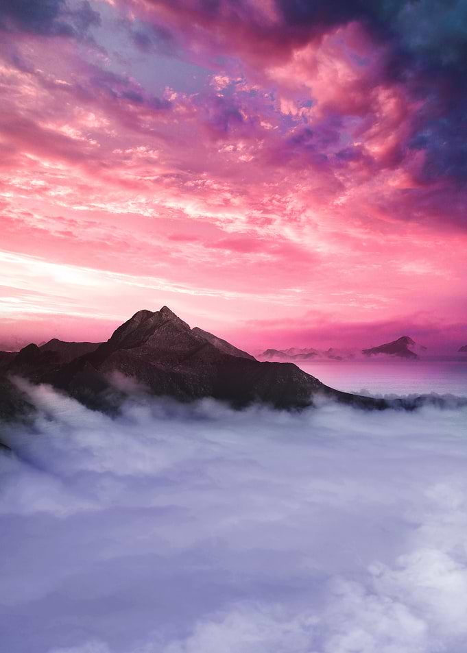 Mountain peak above clouds at sunset
