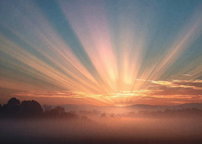 Sunrise over misty landscape
