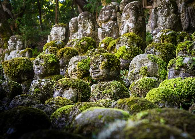 Moss-Covered Stone Statues in Japanese Garden