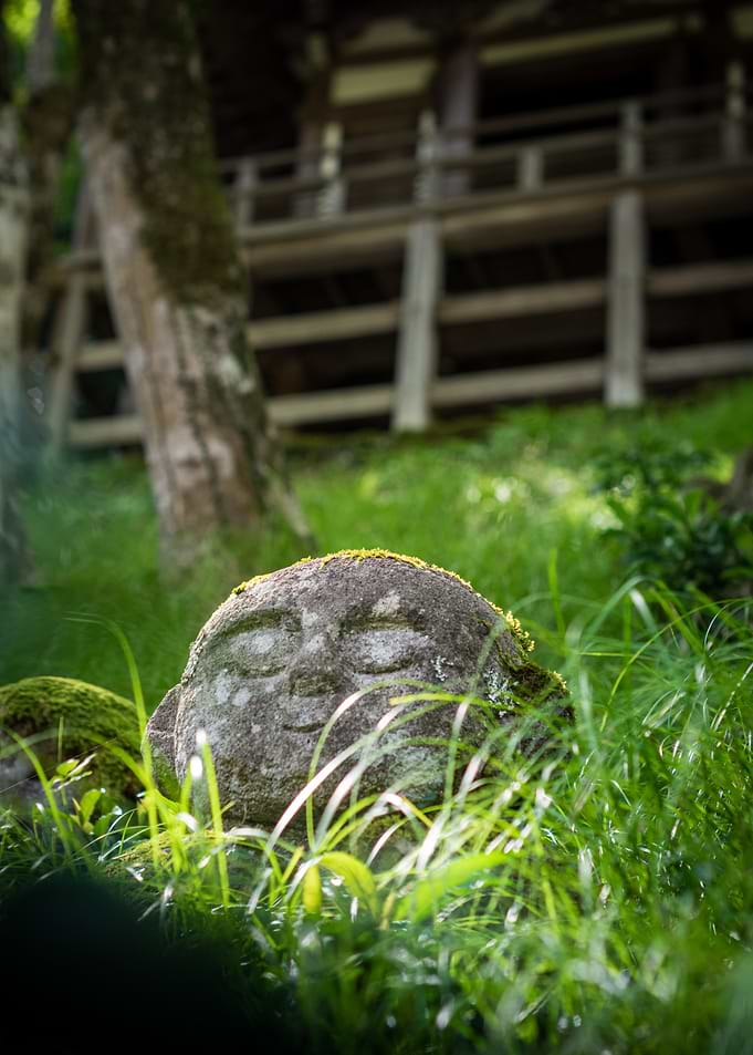 Stone Jizo Statue in Green Grass