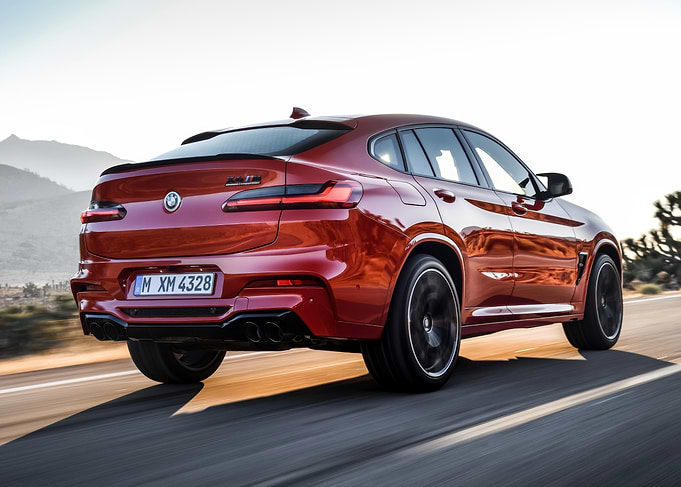 Red BMW X4 M speeding on road
