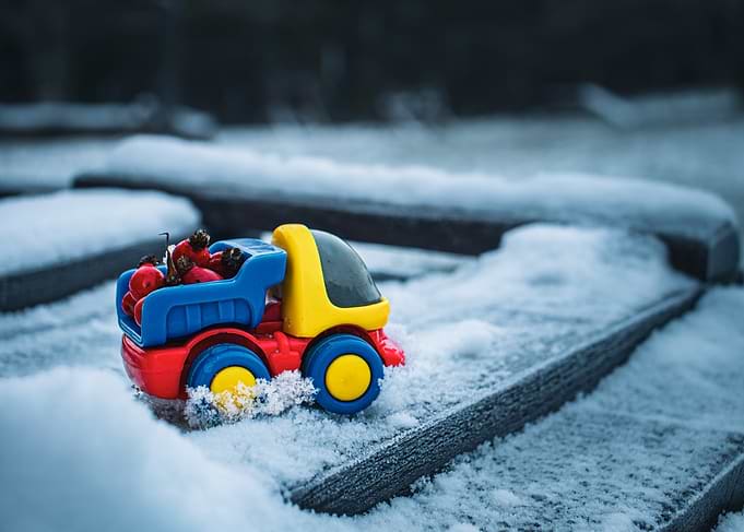 Toy truck in snow with berries