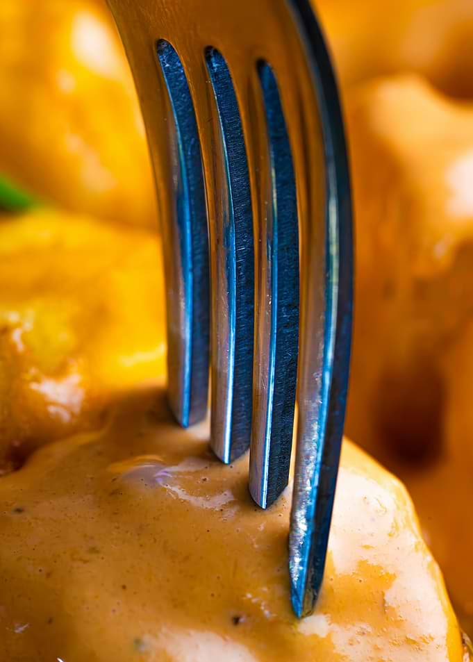 Fork in food with orange sauce