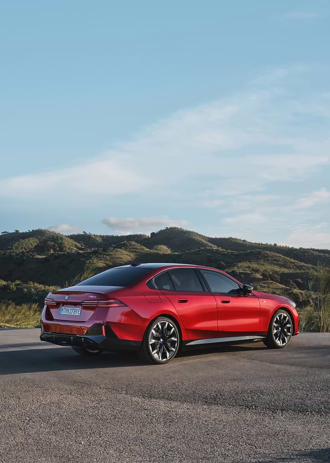 Red BMW on a scenic road