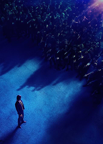 Man facing a crowd in blue light