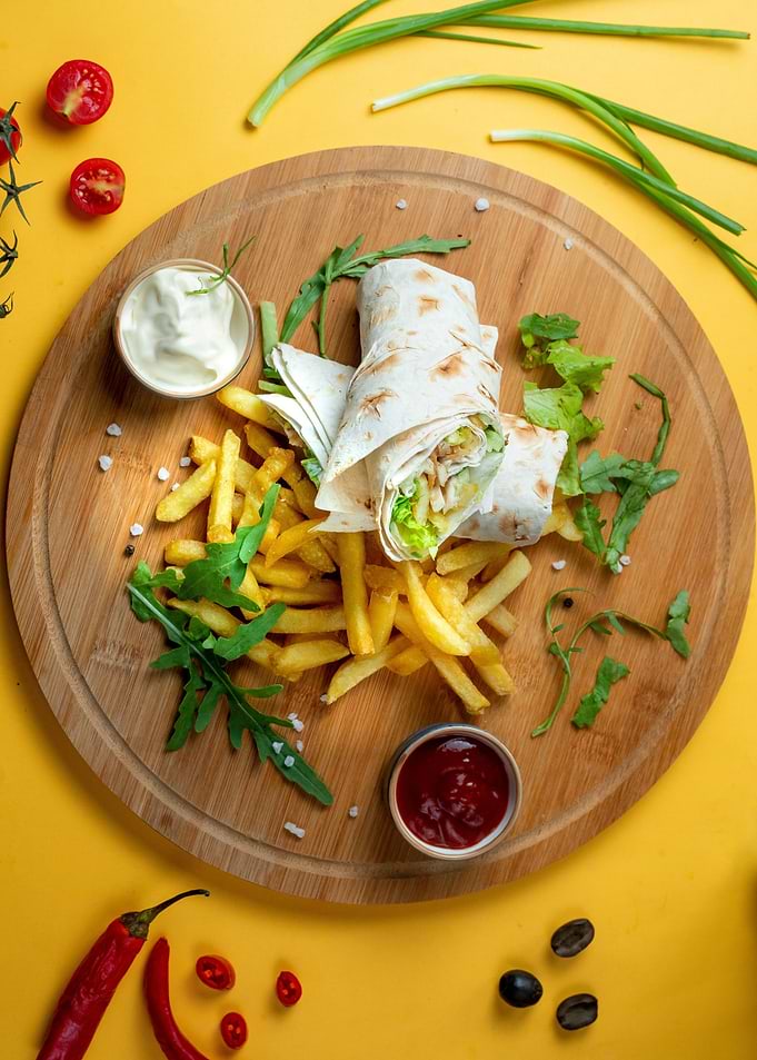 Shawarma with fries on wooden plate
