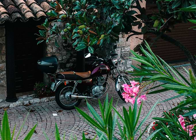 Suzuki Motorcycle Parked Near Stone Building