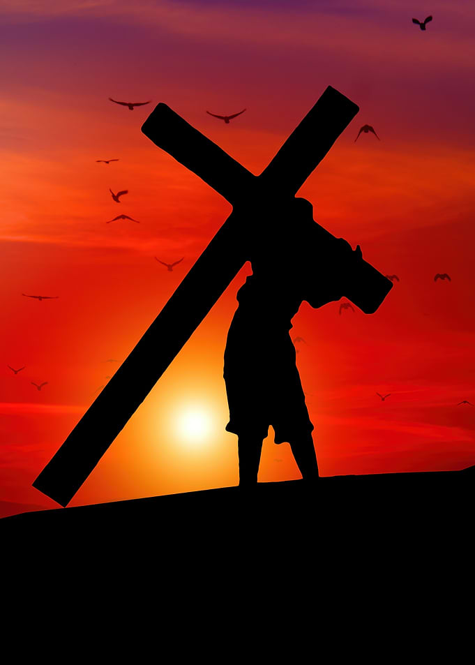 Silhouette of a man carrying cross