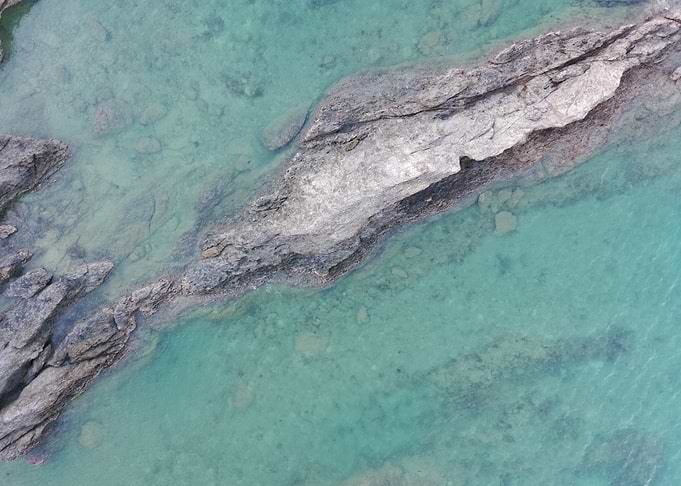 Aerial view of rocks in turquoise water