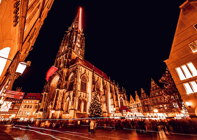 Illuminated Church at Night in Münster with Christmas Market