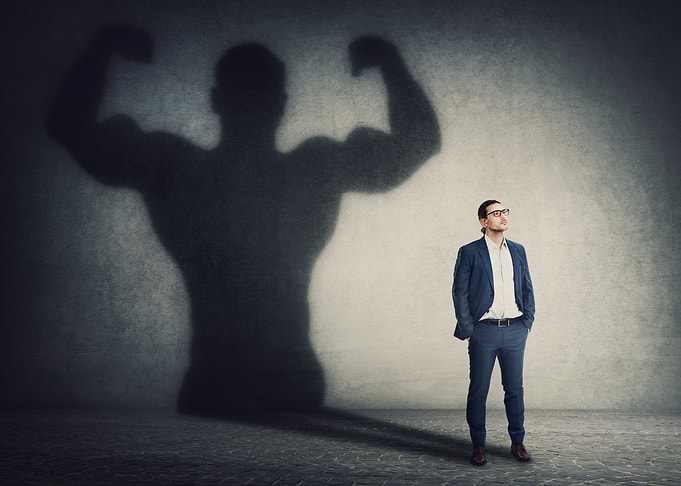 Man with muscular shadow on wall