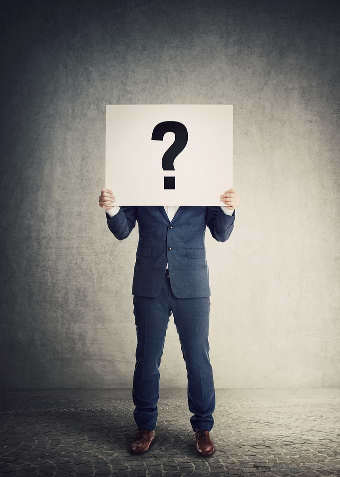 Man in Suit Holding Question Mark