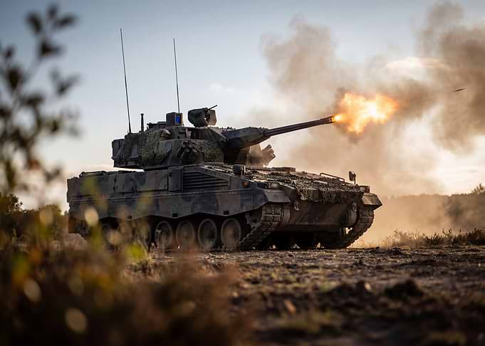 Tank firing on a battlefield