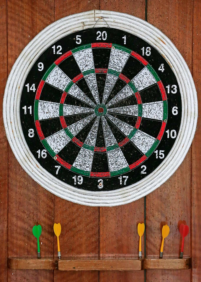 Dartboard with Darts on Wooden Wall
