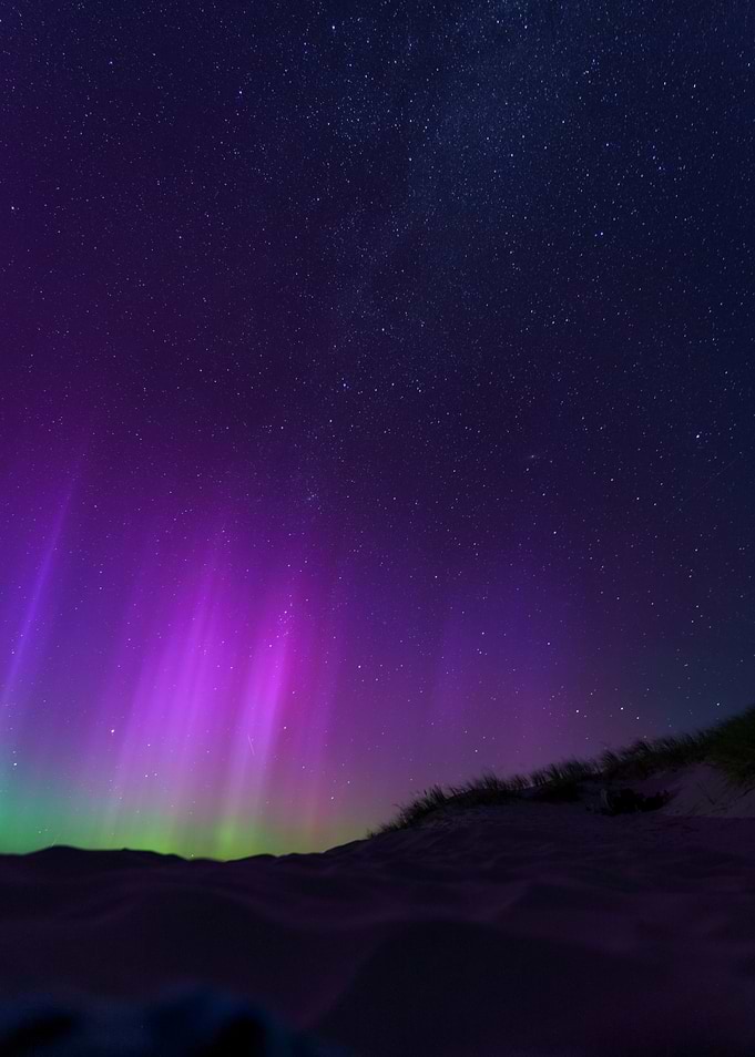 Aurora Borealis over Amrum, Germany with a starry sky in the background