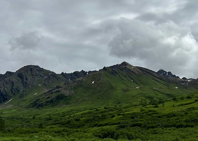 Green Mountain Range Under Cloudy Alaskan Sky